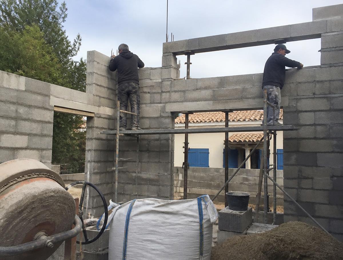 Maçons construisant l'extension en parpaings d'une maison individuelle